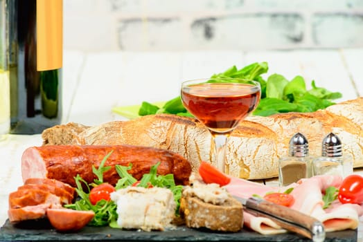 charcuterie plate with wine , bread and tomatoes