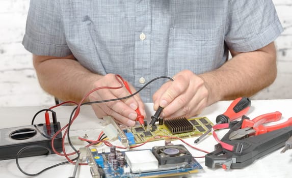 a technician repairing a computer with different tools