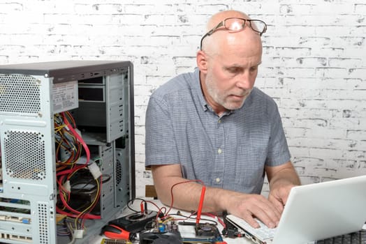 a technician repairing a computer with different tools