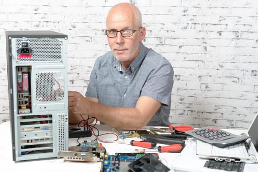 a technician repairing a computer with different tools