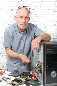 a technician repairing a computer with different tools