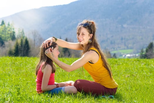 a mother and her daughter with a flower in his mouth in meadow