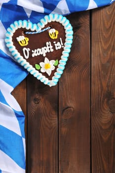 original Bavarian gingerbread heart with Bavarian flag on old weathered wooden boards