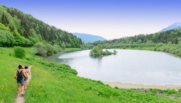 hikers on the edges of a mountain lake