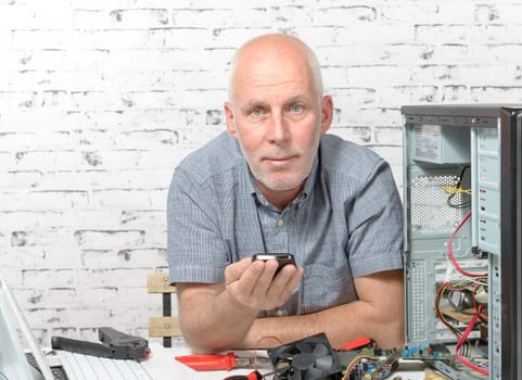 a technician repairing a computer with different tools