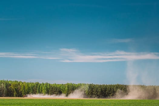 Tractor With Seed Drill Machine Sowing The Seeds For Crops In Spring Season. Beginning Of Agricultural Spring Season. Countryside Rural Field Landscape.
