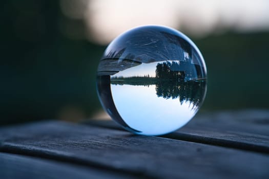 Glass ball on a wooden pier at a Swedish lake at evening hour. Nature shot from Scandinavia