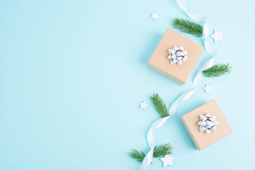 Christmas holiday greeting card with little gift box, pine cones and fir branches, blue background with snow