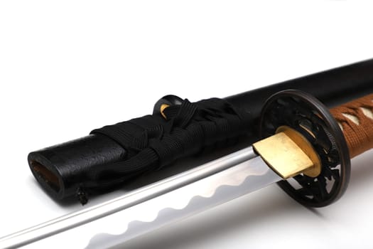 Japanese sword steel fitting and brown cord with black scabbard isolated in white background.