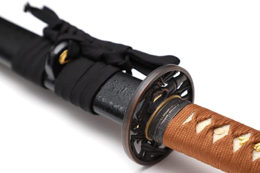 Japanese sword steel fitting and brown cord with black scabbard isolated in white background.