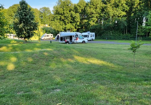 Mobile home with awning and awning and camping table with chairs on the campsite