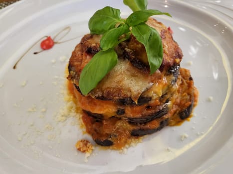 Eggplant parmigiana tower with herb oil, moussaka  or eggplant casserole..