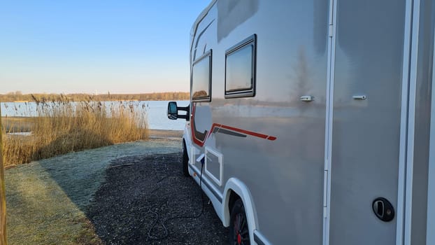 Autumn RV camping. Modern camper van in the late sunny autumn afternoon. Picturesque RV Park.