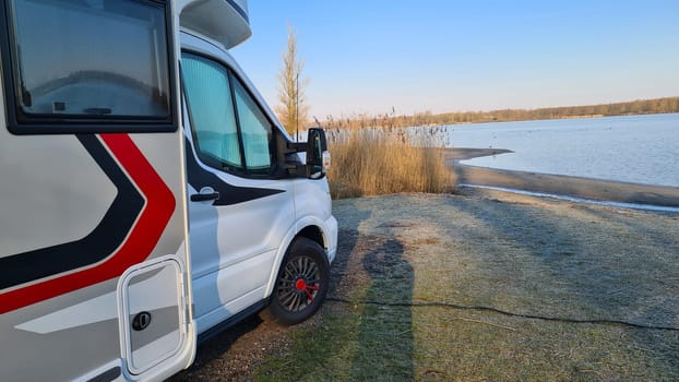 Autumn RV camping. Modern camper van in the late sunny autumn afternoon. Picturesque RV Park.