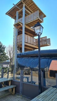 Large observation tower or climbing tower made of wood with a roof