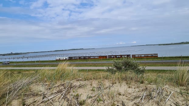 View over the sea from the dune over North Sea and canal in Ouddorp, Zeeland province, The Netherlands. Outdoor scene of coast in Europe nature.