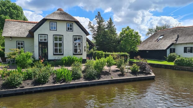 Tranquil view of the village of Giethoorn in the Netherlands, with beautiful country houses, water canals and colorful flowers