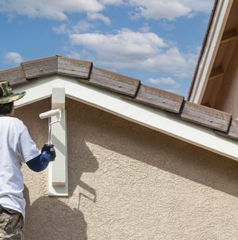 Abstract of Professional Painter Using A Roller to Paint House Details.