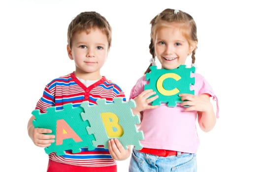 boy and girl are holding colorful letters