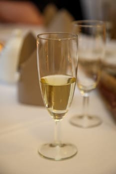 A half-filled glass of champagne on a party table.