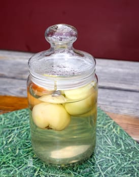 In a jar with a lid in the water apples.
