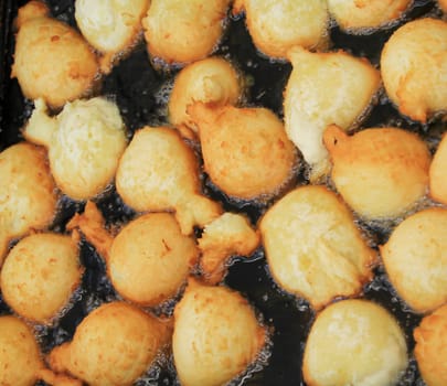 Quarkbällchen are small doughnuts made of yeast dough which are baked here in an oil bath.