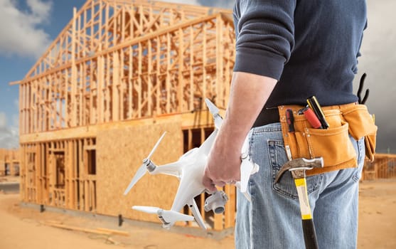 Construction Worker and Drone Pilot With Toolbelt Holding Drone At Construction Site.