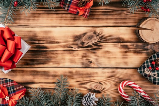 Burnt wood background image with fir branches, gift and Christmas decorations. Happy New Year and Merry Christmas. Top view. Copy space