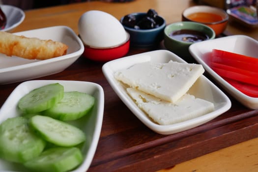 A vibrant breakfast layout featuring vegetables, cheese, and olives.