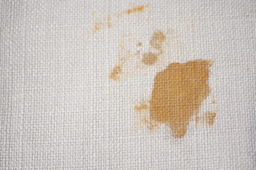 A noticeable stain appears on a light-colored fabric background.