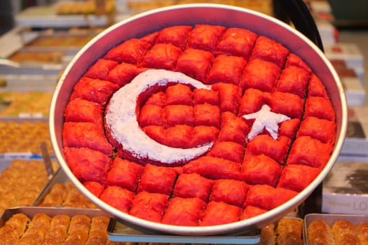 Colorful tray of baklava with Turkey's flag design displayed for sale.