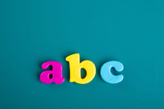 Colorful Alphabet magnetic letters on green background