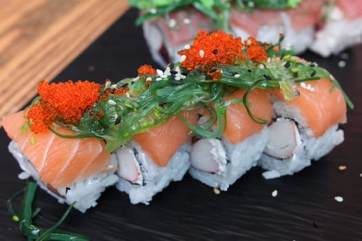 SET OF SALMON SUSHI ON CERAMIC BLACK PLATE