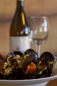 plate of mussels with wine and glass on background