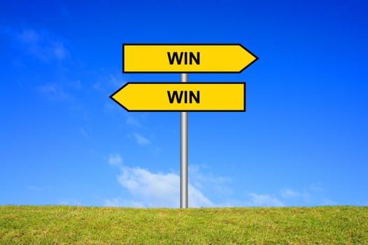 Signpost on meadow in front of blue sky shows Win Win