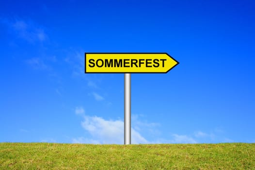 sign signpost on grass against a blue sky showing summer festival