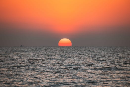 Sundown Above Sea Horizon At Sunset. Natural Sunrise Sky Warm Colors Over Ocean. Big Sun Over Sea Waters