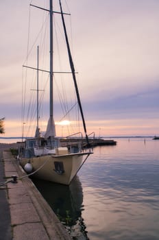 Sailing ship in the harbor of lake Vaettern at sunset. Lighthouse in the background. Landscape shot from Scandinavia