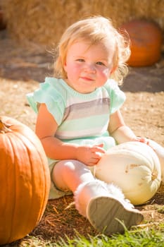Adorable Baby Girl Having Fun in a Rustic Ranch Setting at the Pumpkin Patch.