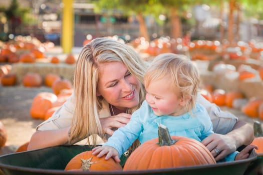 Adorable Young Mother and Daughter Enjoys a Day at the Pumpkin Patch.