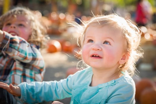 Sweet Little Boy Plays with His Baby Sister in a Rustic Ranch Setting at the Pumpkin Patch.