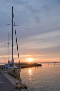 Sailing ship in the harbor of lake Vaettern at sunset. Lighthouse in the background. Landscape shot from Scandinavia
