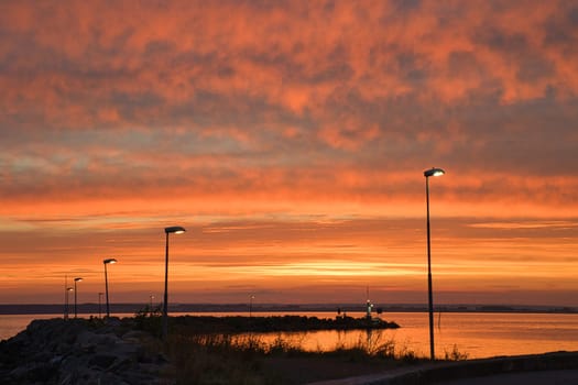 Sunset in Sweden at the harbor of lake Vaettern. Lighthouse in the background at dusk. Landscape shot in Scandinavia.