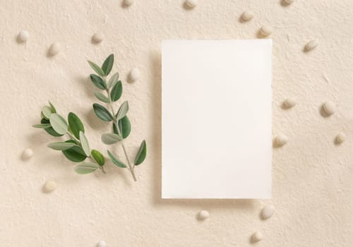 Blank card near eucalyptus branches andpebble stones top view on beige, mockup. Romantic scene with vertical card. Bohemian greeting or wedding Invitation.
