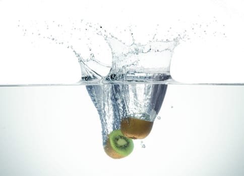 Two half kiwi splashing in water forming crown splash. On white background.
