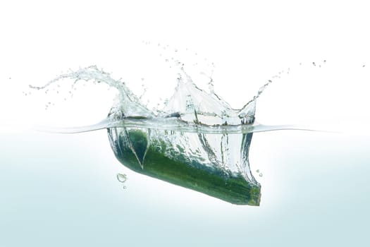 Zuchini splashing in water. Side view on white background.