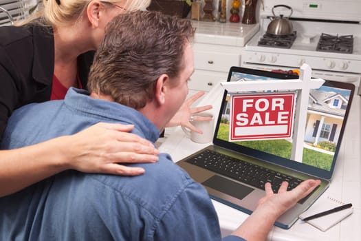 Couple In Kitchen Using Laptop to Research Real Estate. Picture on screen is my copyright as well.
