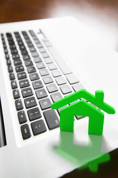 House Icon Resting on Laptop Keyboard