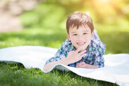 Mixed Race Chinese and Caucasian Young Boy Relaxing Outside On The Grass