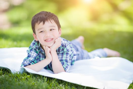 Mixed Race Chinese and Caucasian Young Boy Relaxing Outside On The Grass